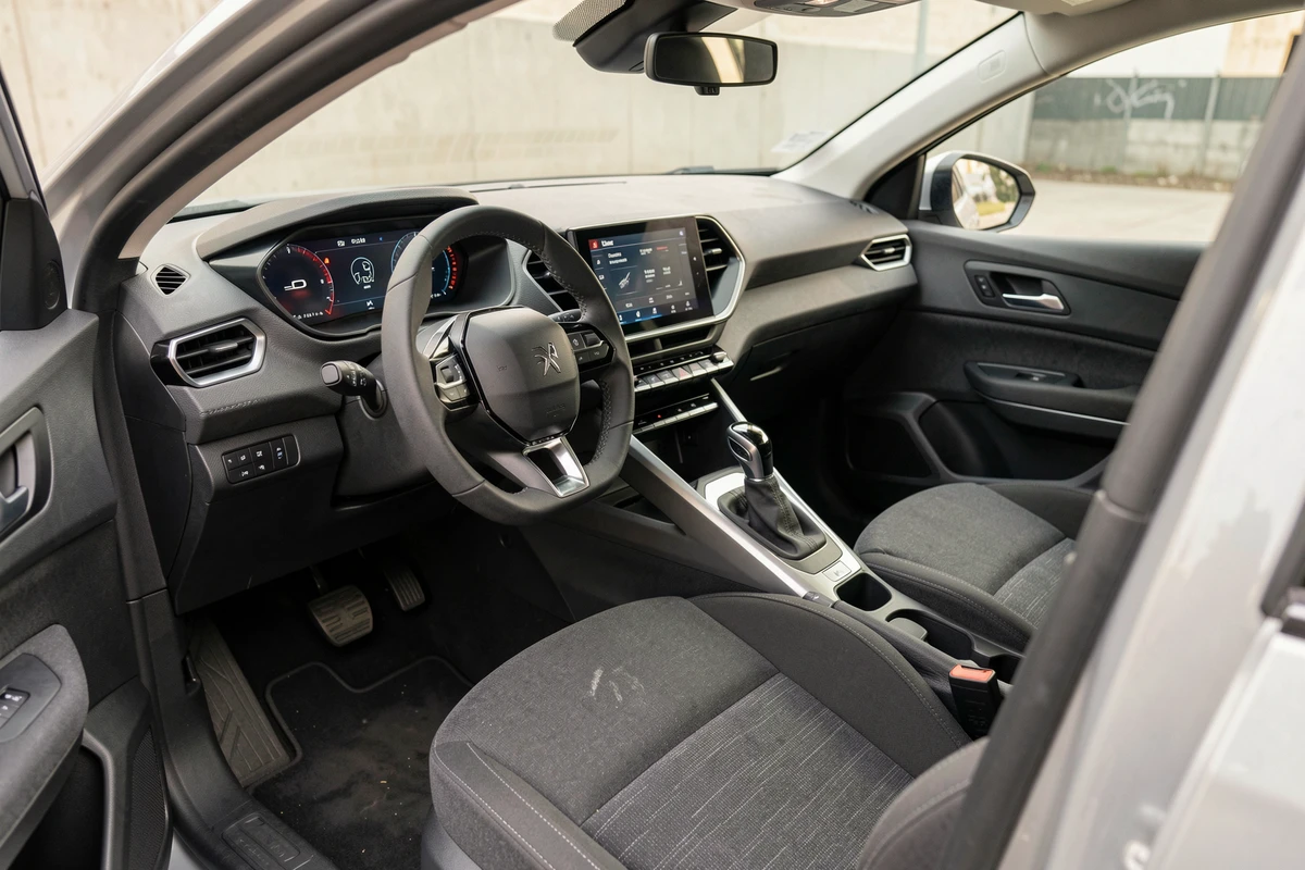 Intérieur de la Peugeot 2026 d'occasion montrant le tableau de bord, l'écran tactile et les sièges tissu