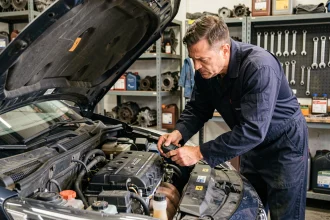 Mécanicien inspectant un moteur PureTech 3 cylindres dans un garage automobile professionnel